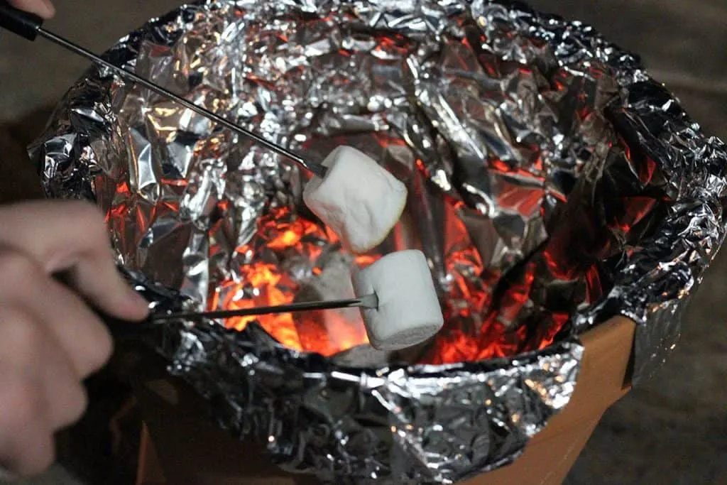 toasting marshmallows over terra cotta pot smore maker