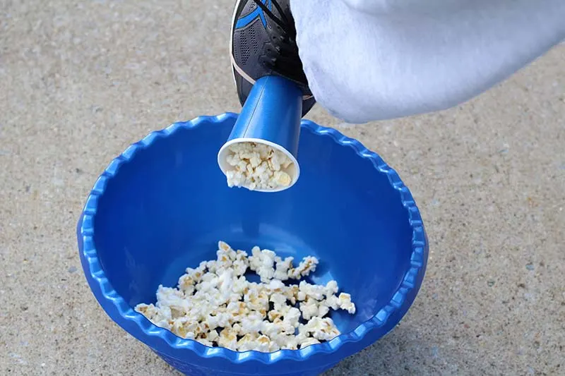dumping popcorn in bowl